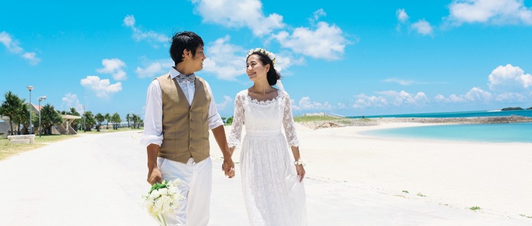 タキシードとドレスで浜辺を歩く夫婦